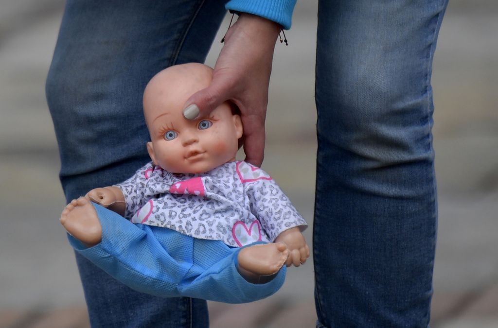 Seorang aktivis meletakkan boneka dalam aksi menentang pelecehan seksual pada anak di alun-alun Bolivar, Bogota, Senin (30/11/2020). Ribuan mainan lucu bertebaran di sekitar alun-alun utama Bogota sebagai pesan menolak kekerasan seksual yang mengancam 37 anak setiap harinya di Kolombia.
