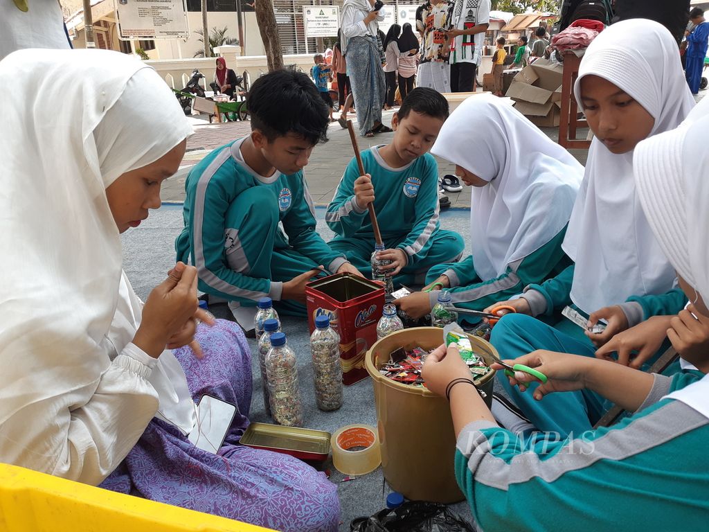 Para pelajar mempraktikkan proses pengolahan sampah, Sabtu (28/10/2023), dalam acara Hajatan Pulang Babang di Pulau Pramuka, Kepulauan Seribu, DKI Jakarta. 