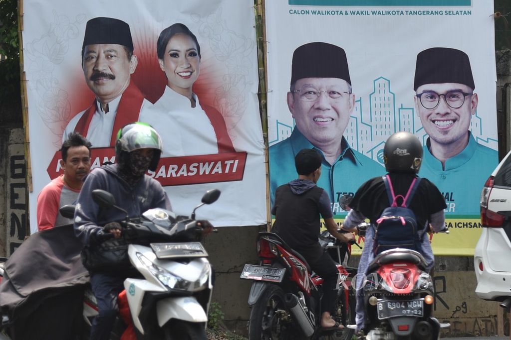 Pengendara melintasi baliho pasangan calon wali kota dan wakil wali kota Tangerang Selatan di kawasan Pondok Aren, Tangerang Selatan, Banten, Kamis (1/10/2020).