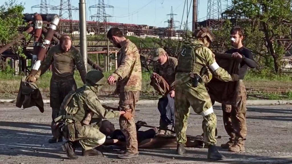 Foto hasil tangkapan video yang dirilis oleh Kementerian Pertahanan Rusia pada 17 Mei 2022 ini memperlihatkan personel militer pro-Rusia menggeledah anggota tentara Ukraina yang keluar dari pabrik baja Azovstal di Mariupol. 