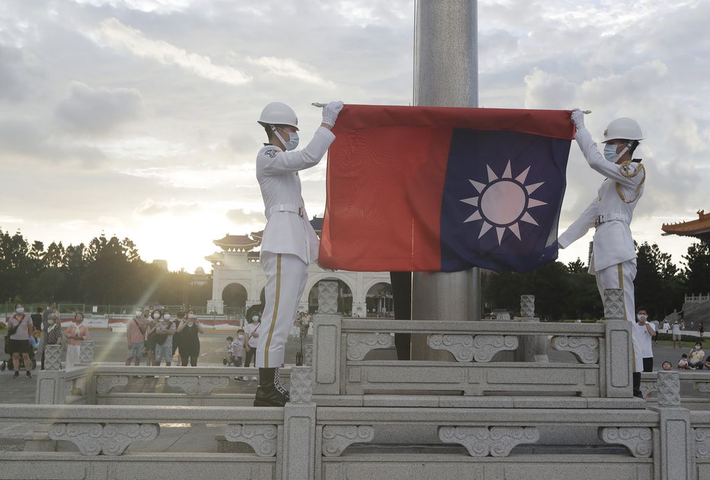 Dua anggota militer melipat bendera Taiwan seusai menurunkannya dari tiang bendera di Liberty Square of Chiang Kai-shek Memorial Hall in Taipei, Taiwan, Sabtu (30/7/2022).