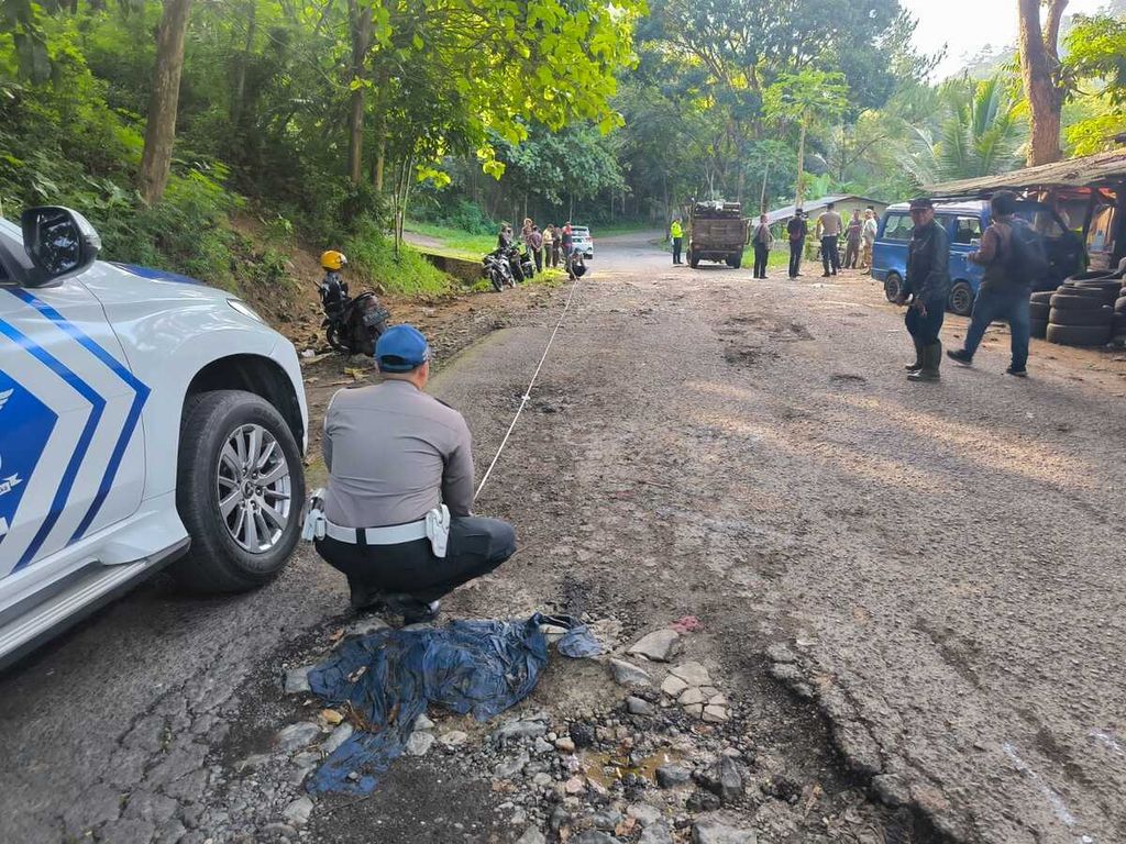 Polisi melakukan olah tempat kejadian perkara di lokasi truk mengalami kecelakaan tunggal di Desa Saguling, Kabupaten Bandung Barat, Jawa Barat, Jumat (26/1/2024). Lima penumpang truk tewas dalam peristiwa ini.