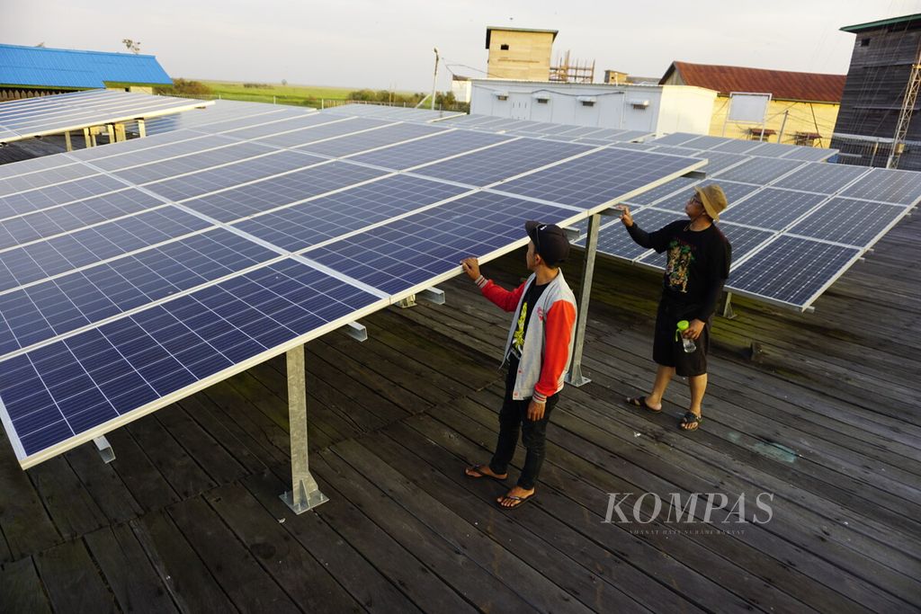 Warga Desa Muara Enggelam, Kecamatan Muara Wis, Kabupaten Kutai Kartanegara, Kalimantan Timur, mengecek kondisi panel surya berkapasitas 42 kWp, Sabtu (23/11/2019).