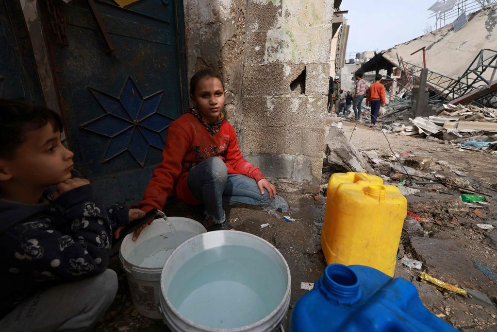 Anak-anak Palestina mengambil air di Rafah pada Senin (12/2/2024).