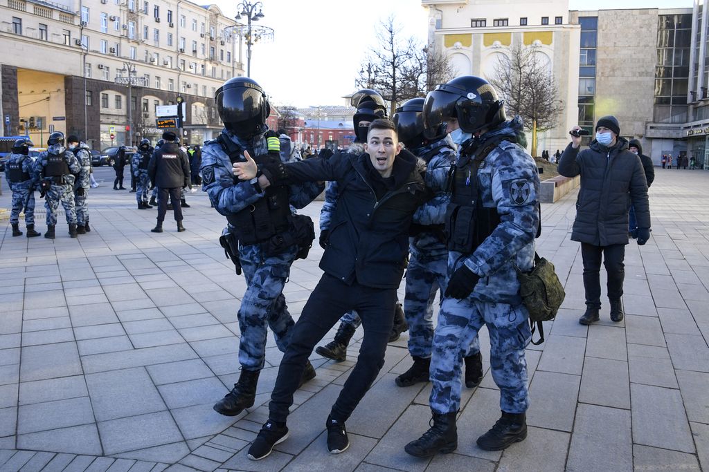 Polisi mengamankan seorang pengunjuk rasa dalam protes menentang invasi Rusia ke Ukraina di pusat kota Moskwa, 27 Februari 2022. 