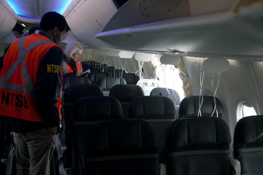 Dalam foto yang dirilis Dewan Keselamatan Transportasi Nasional (NTSB), Penanggung Jawab NTSB John Lovell memeriksa area sumbat badan pesawat Alaska Airlines Penerbangan 1282 pada 7 Januari 2024 di Portland, Oregon, AS. 