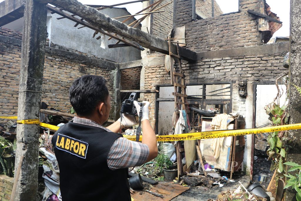 Petugas Laboratorium Forensik Polri melakukan pemeriksaan di rumah yang terbakar di Kelurahan Sitirejo III, Medan Amplas, Medan, Sumatera Utara, Selasa (18/4/2023). Enam orang satu keluarga meninggal karena kebakaran itu. 