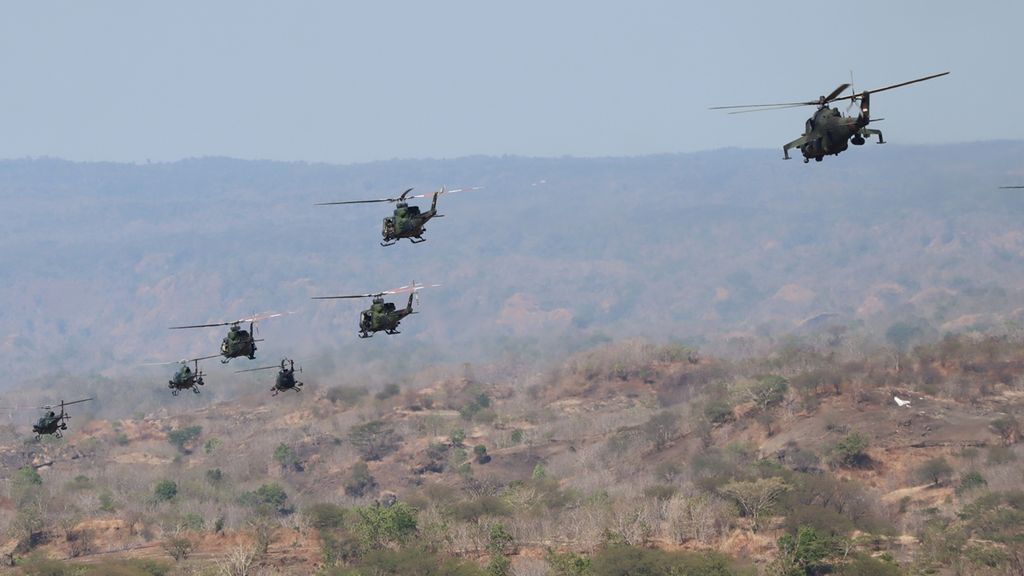 Sejumlah helikopter melintas di atas medan pertempuran seusai melakukan serangkaian serangan ke musuh pada latihan gabungan TNI dengan sandi ”Dharma Yudha 2019”, di Titik Pantau 12 Pusat Latihan Tempur Marinir Asembagus, Situbondo, Jawa Timur, Kamis (12/9/2019).