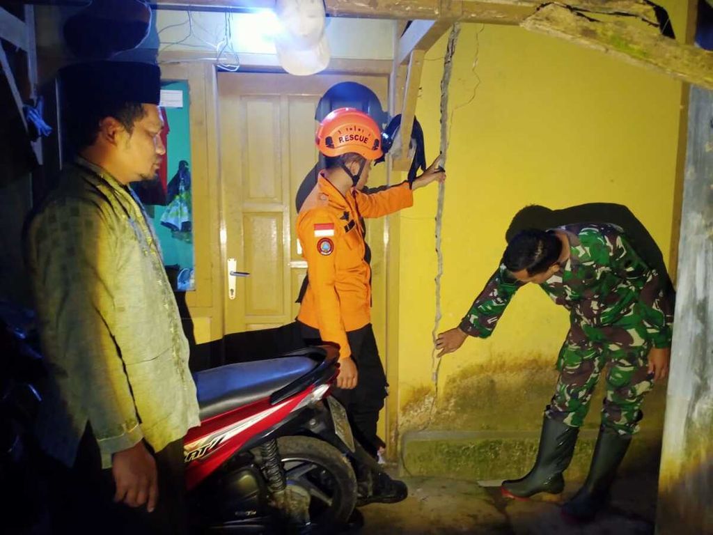 Petugas mengecek rumah yang rusak akibat gempa bumi di Wonosobo, Jawa Tengah, Jumat (30/6/2023) malam.