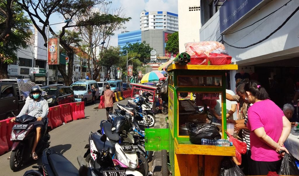 Kendaraan roda dua terparkir di bahu Jalan Pancoran. Warga ramai mengunjungi kawasan pecinan Pancoran, Glodok, Jakarta Barat, Minggu (3/7/2022).