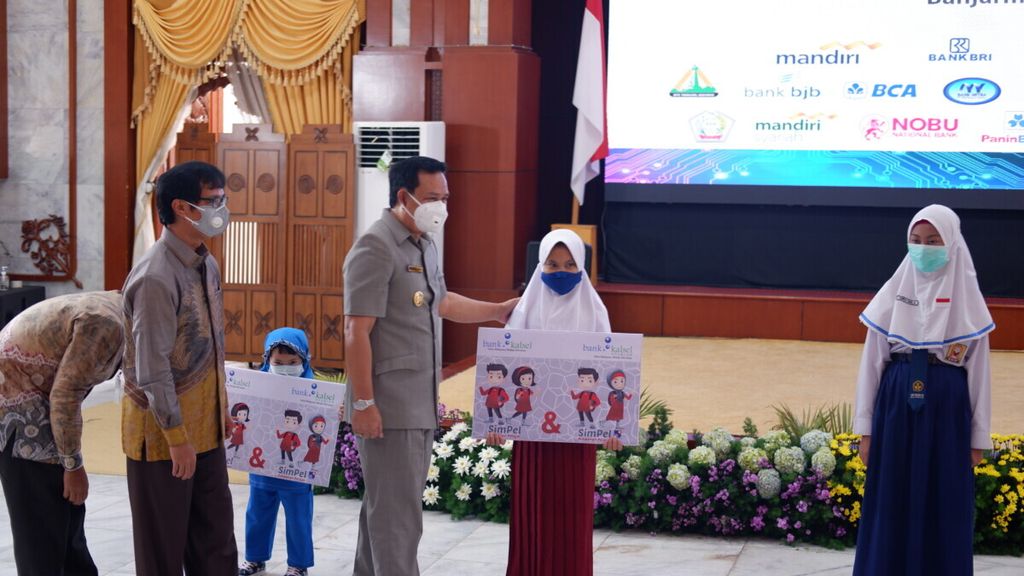 Pelaksana Tugas Gubernur Kalimantan Selatan Rudy Resnawan (ketiga dari kanan) menyerahkan secara simbolis buku rekening tabungan kepada pelajar di Banjarmasin, Senin (9/11/2020).