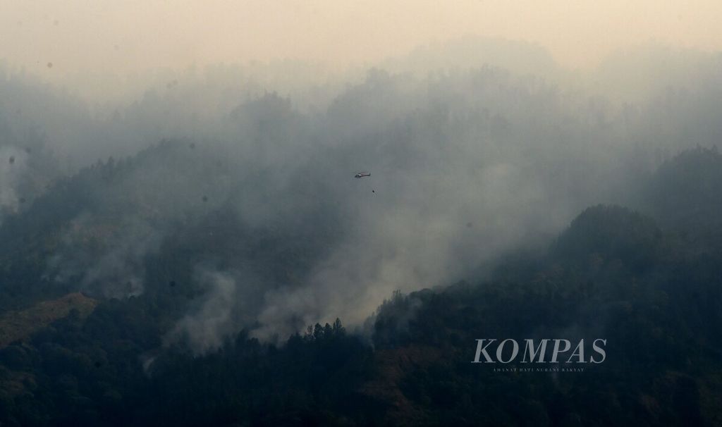 Helikopter BNPB yang sedang melaksanakan <i>water bombing</i> terbang di atas kawasan kebakaran hutan dan lahan Gunung Arjuno di Kecamatan Prigen, Kabupaten Pasuruan, Selasa (5/9/2023). 