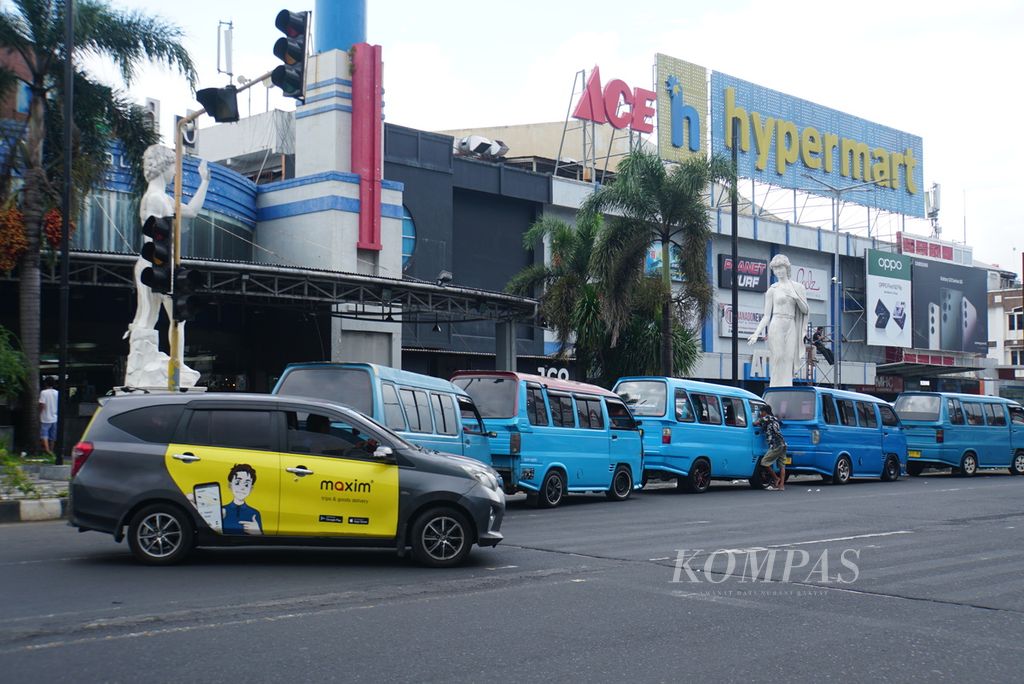 A Maxim online taxi passes near a line of microbuses or microbuses in front of the Manado Townsquare mall, Manado, North Sulawesi, on Saturday (13/5/2023).