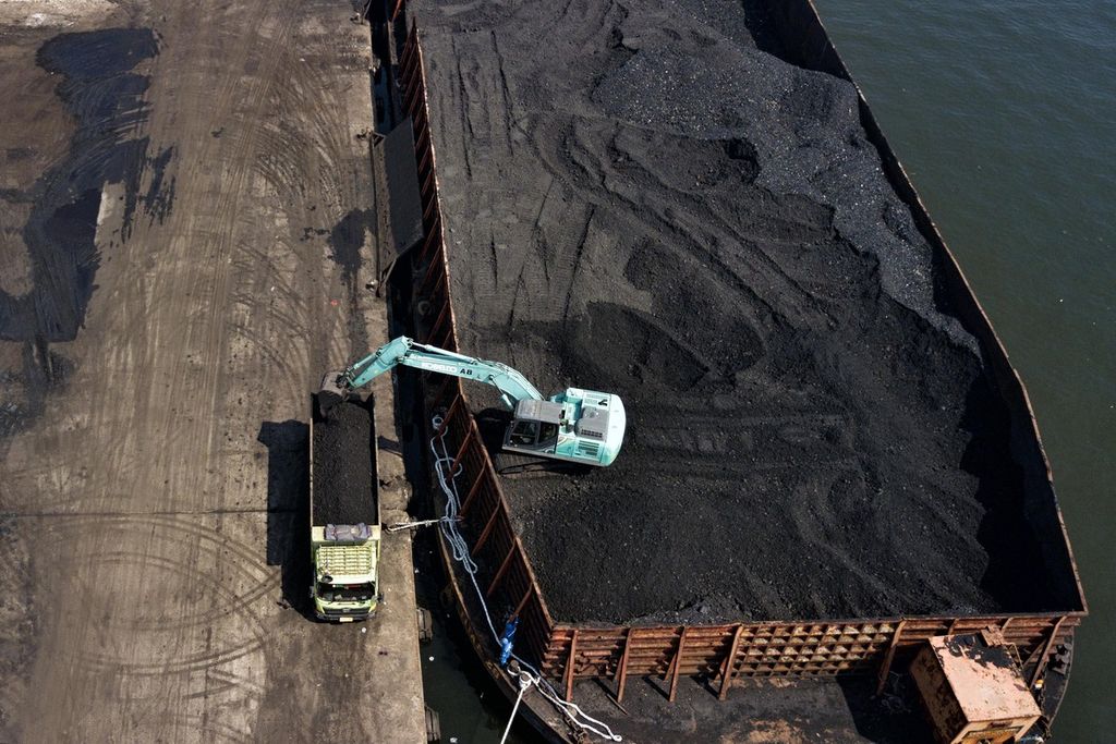 Pemindahan batubara yang didatangkan dari Kalimantan dari dalam tongkang ke atas truk di Pelabuhan KCN Marunda, Jakarta Utara, Rabu (5/1/2022).