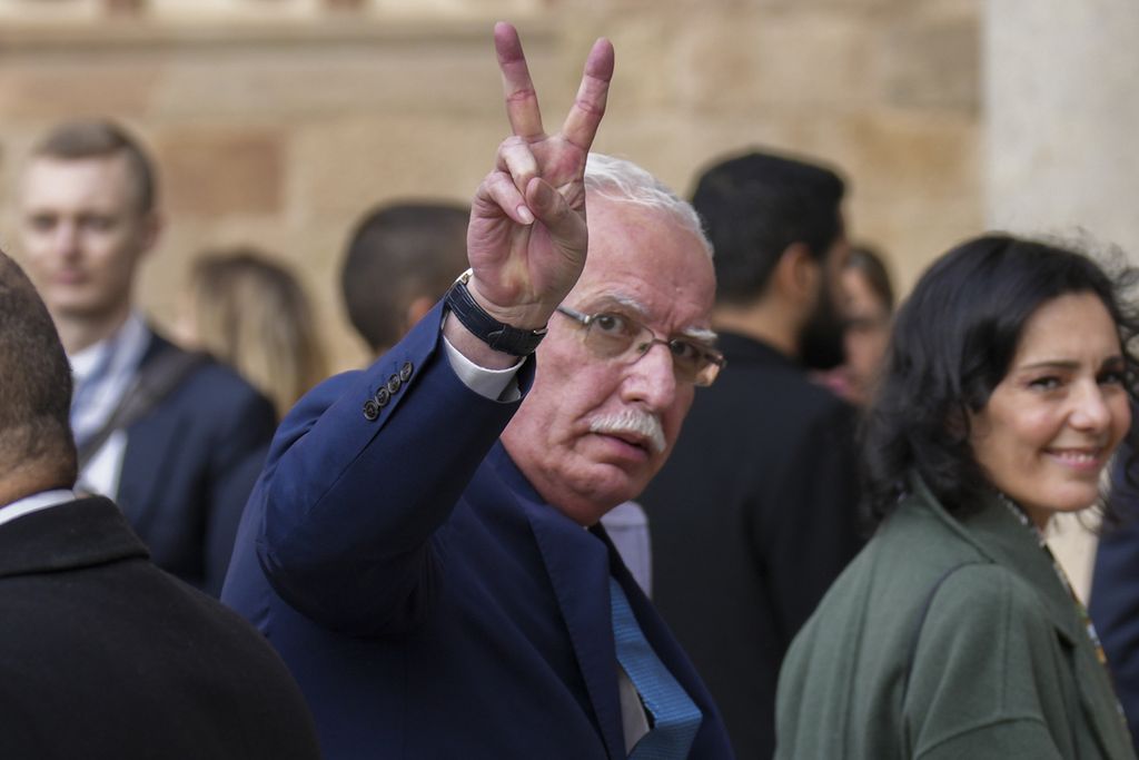 Menteri Luar Negeri Palestina Riyad al-Malik mengangkat tangan kanannya memperlihatkan simbol V atau <i>victory </i>yang biasa digunakan sebagai simbol perdamaian atau kemenangan, jelang pertemuan negara-negara Timur Tengah, Afrika Utara, dan Uni Eropa di Barcelona, Spanyol, Senin (27/11/2023).  