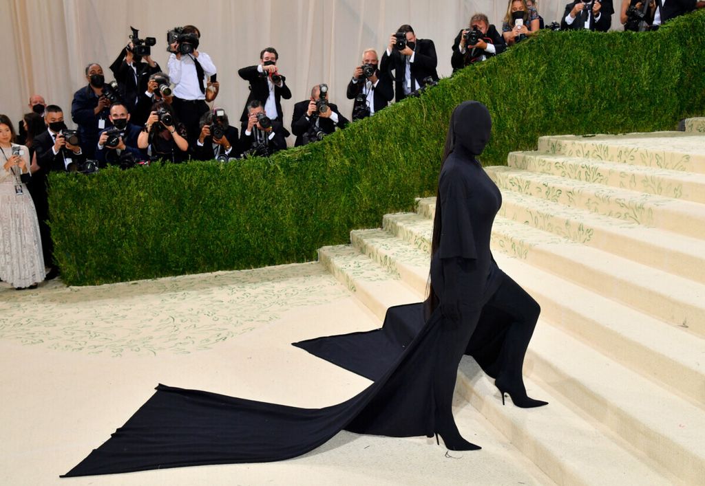 Kim Kardashian yang mengenakan busana tertutup serba hitam saat hadir pada acara Met Gala di Metropolitan Museum of Art, New York, Amerika Serikat, Minggu (13/9/2021). Bintang televisi ini didenda lebih dari 1 juta dollar AS karena unggahannya terkait aset kripto di media sosial.