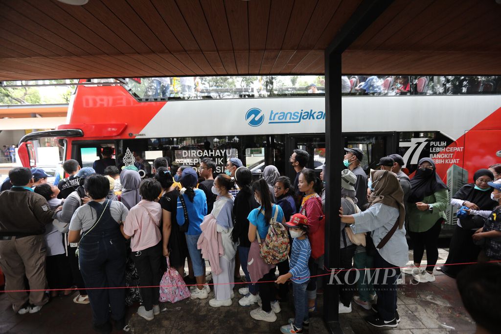 Warga antre masuk ke bus wisata Transjakarta di Halte Monas, Jakarta, Selasa (25/4/2023). Bus Transjakarta menjadi salah satu wisata favorit bagi warga Ibu Kota. 