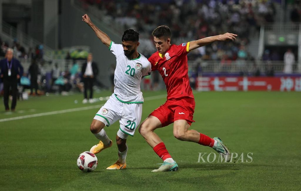 Pemain Kirgistan, Khristiian Brauzman (kanan), dan pemain Oman, Salaah Said al-Yahyaei, pada pertandingan terakhir fase Grup F Piala Asia 2023 di Stadion Abdullah bin Khalifa, Doha, Qatar, Kamis (25/1/2024). Laga berakhir imbang dengan skor 1-1 sehingga Indonesia lolos ke fase gugur.