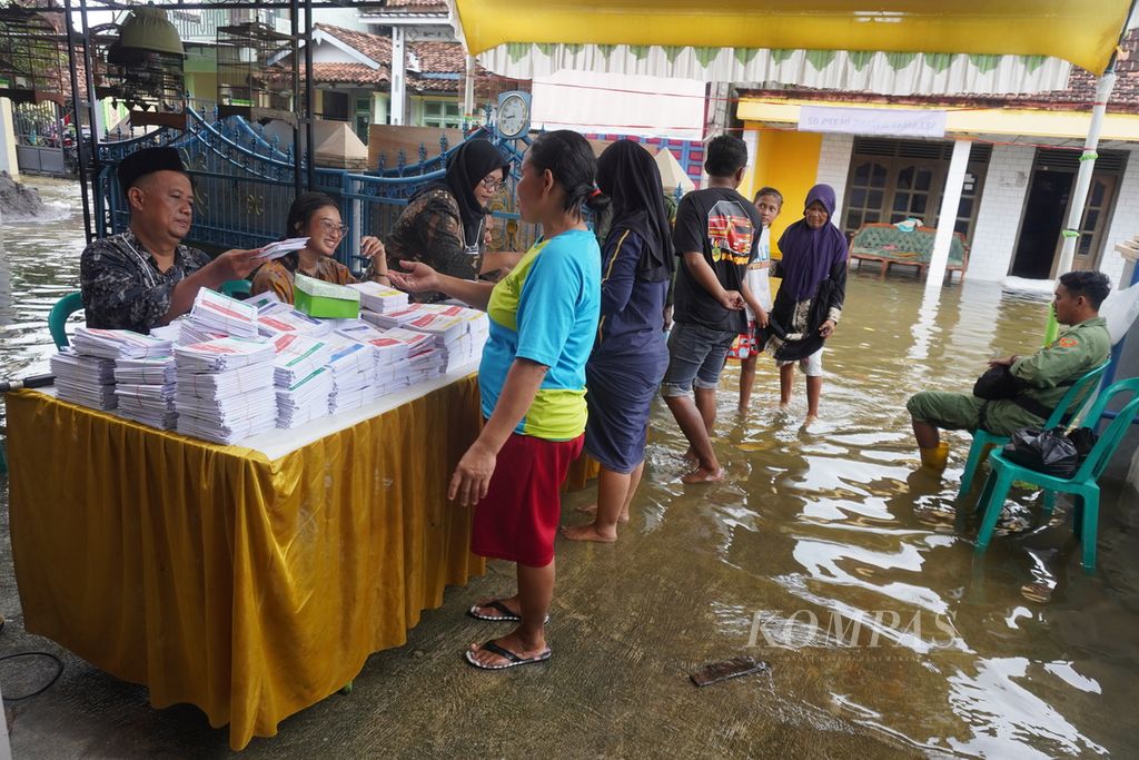 Voters lined up before exercising their right to vote at Polling Station 02 in Ngelowetan Village, Mijen District, Demak Regency, Central Java, on Wednesday (14/2/2024). Despite the flooding, many residents in the area remained enthusiastic about participating in the election.