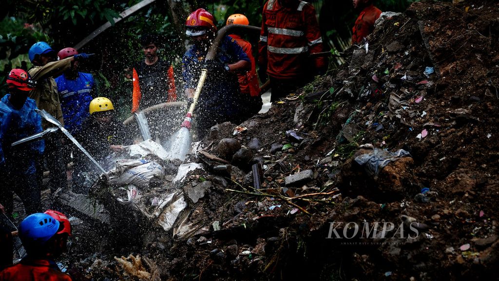 Percikan semprotan air yang mengenai puing-puing saat para petugas SAR gabungan melakukan pencarian korban yang masih tertimbun longsor di Kampung Sirnasari, Empang, Kota Bogor, Jawa Barat, Rabu (15/3/2023). 