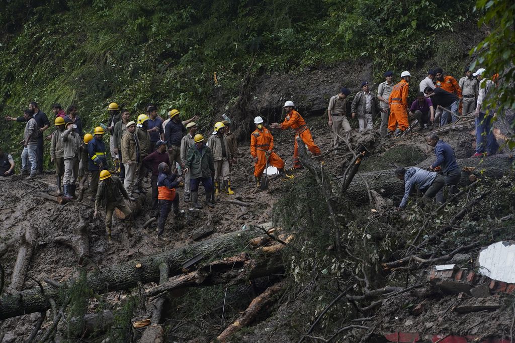 Petugas penyelamat memindahkan puing-puing dan lumpur saat mencari korban yang diperkirakan terjebak setelah tanah longsor menimbun sebuah kuil di pinggiran kota Shimla, Himachal Pradesh, India, 14 Agustus 2023. 