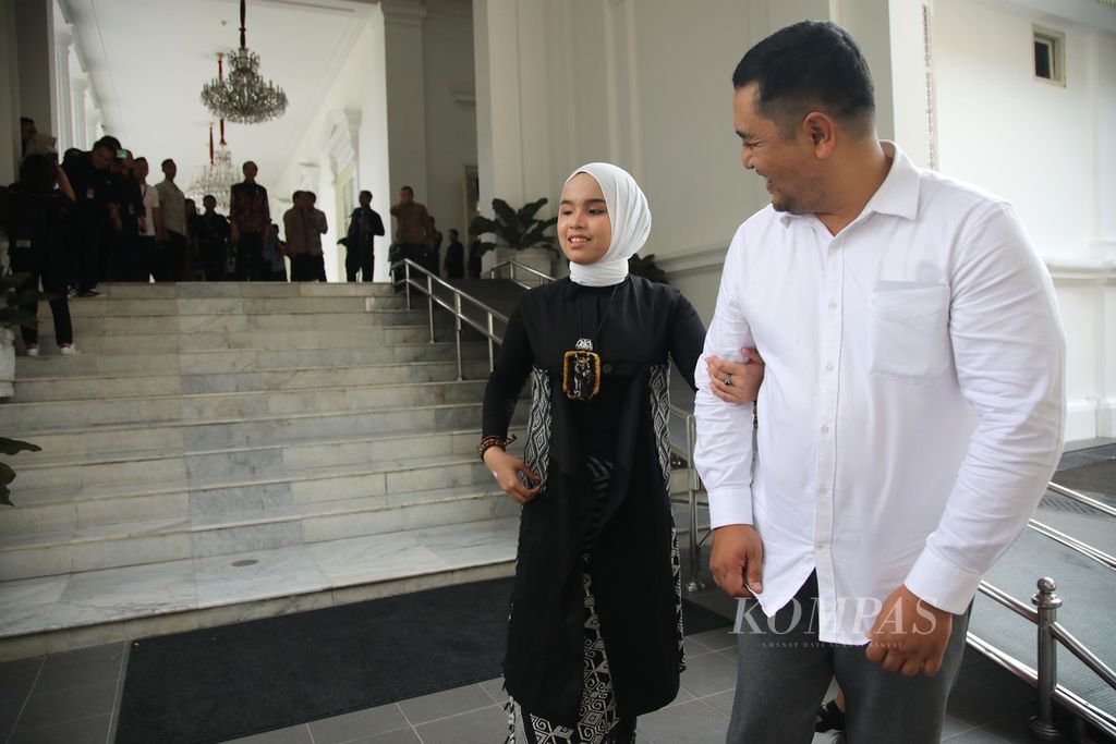 Penyanyi Putri Ariani didampingi orangtuanya meninggalkan Istana Merdeka, Jakarta, seusai bertemu Presiden Joko Widodo, Rabu (14/6/2023). 