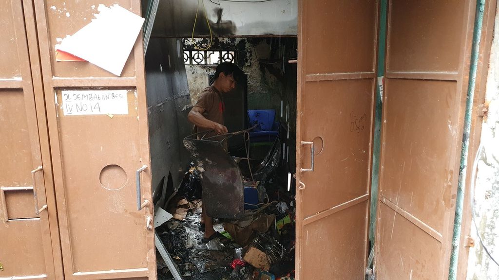 Budiman (31) mengais sisa harta yang tersisa setelah kebakaran sebanyak tujuh rumah di Jalan Jembatan Besi IV, RT 006 RW 003, Kelurahan Jembatan Besi, Kecamatan Tambora, Jakarta Barat, terbakar pada Selasa (6/6/2023).