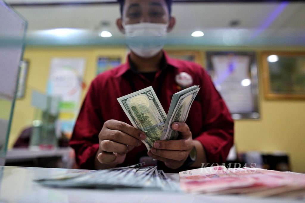 Petugas menghitung uang dollar AS di tempat penukaran valuta asing Dolarindo di kawasan Melawai, Jakarta Selatan, Senin (6/12/2021). Menurut kurs referensi Jakarta Interbank Spot Dollar Rate (Jisdor), nilai tukar rupiah pada Senin Rp 14.441 per dollar AS atau melemah 33 poin dibandingkan akhir pekan lalu.