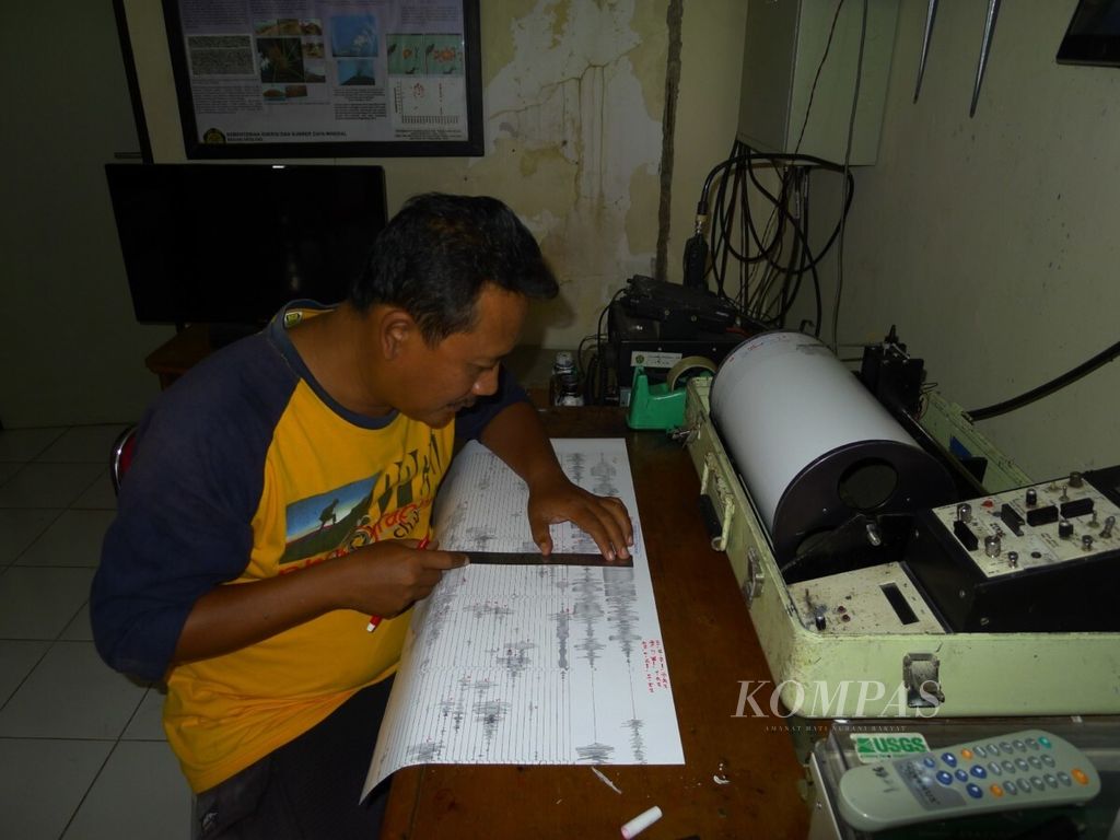 Petugas Pos Pengamatan Gunung Anak Krakatau memberi tanda pada seismogram di Desa Pasauran, Kecamatan Cinangka, Kabupaten Serang, Banten, Senin (20/8/2018). Aktivitas Anak Krakatau meningkat berdasarkan jumlah letusannya.