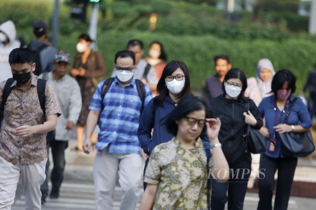 Warga berjalan di kawasan Jalan MH Thamrin, Jakarta, saat berangkat kerja dengan mengenakan masker, Kamis (10/8/2023). 