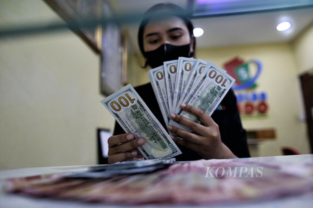 Seorang petugas menunjukkan uang dollar Amerika Serikat di tempat penukaran valuta asing Dolarindo di kawasan Blok M, Jakarta Selatan, Rabu (27/7/2022).