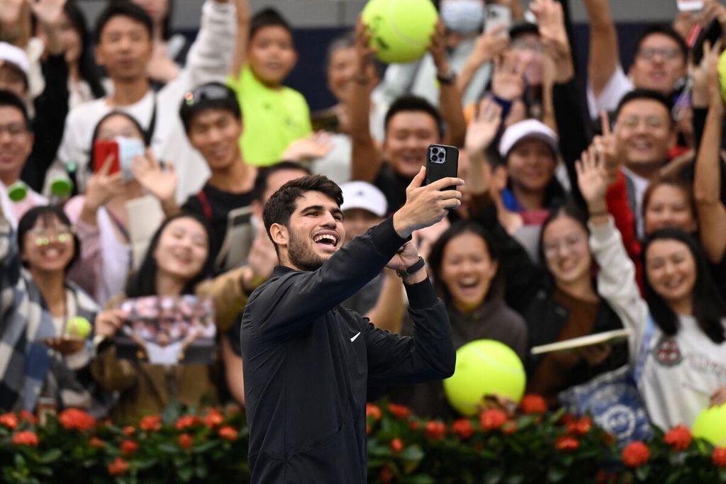 Carlos Alcaraz melakukan swafoto bersama para penonton setelah memenangi pertandingan melawan Giovanni Mpetshi Perricard pada turnamen tenis ATP 500 Beijing, China, Jumat (27/9/2024). 