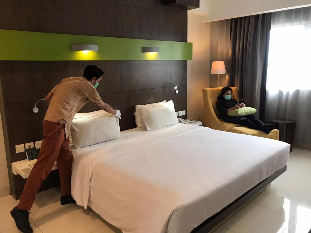 Petugas membersihkan tempat tidur di Hotel Santika Karawang, Jawa Barat.
