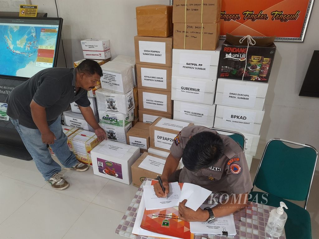 Petugas satpam BPBD Sumatera Barat mencatat bantuan rendang yang masuk untuk korban gempa M 5,6 Cianjur di kantor badan tersebut, Padang, Sumbar, Rabu (23/11/2022) siang. Pemerintah Provinsi Sumbar melalui BPBD provinsi menghimpun bantuan rendang dari berbagai kalangan pada 22-24 November 2022.