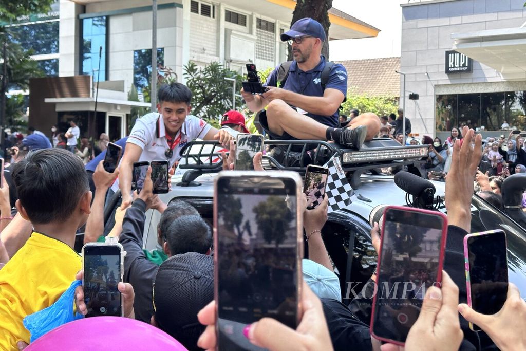 Pebalap muda Indonesia yang membela tim Moto3 Honda Team Asia, Mario Suryo Aji, menyapa warga.