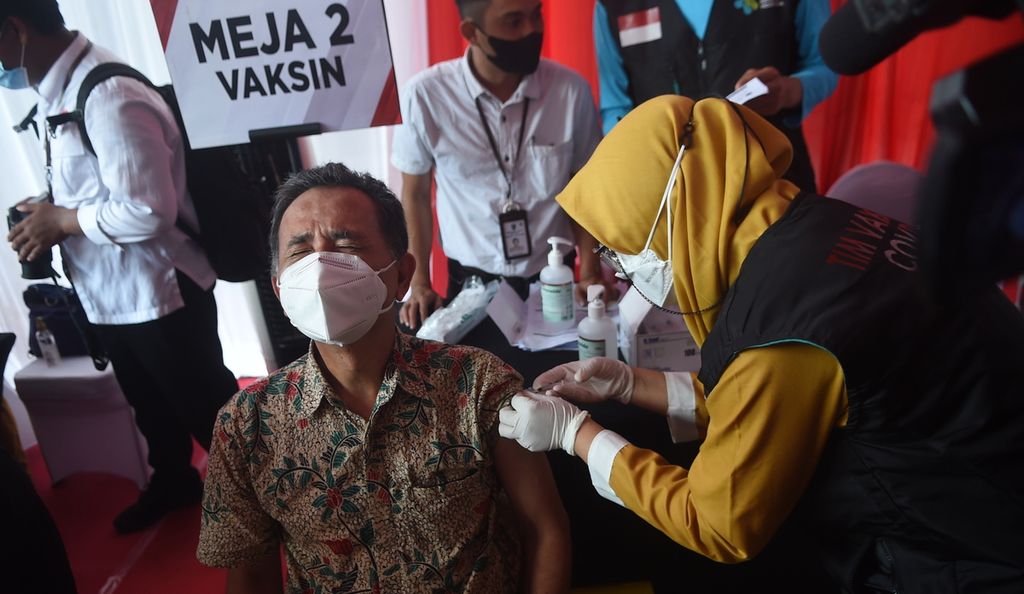 Warga mendapatkan vaksinasi saat Kick Off Vaksinasi Booster Jawa Timur di Kantor Dinas Ketenagakerjaan Jatim, Kota Surabaya, Rabu (12/1/2022). Sebanyak 100 warga menjalani vaksin <i>booster </i>tersebut. Sasaran vaksin <i>booster </i>ditujukan bagi masyarakat berusia 18 tahun ke atas dengan prioritas warga lansia. Kompas/Bahana Patria Gupta 