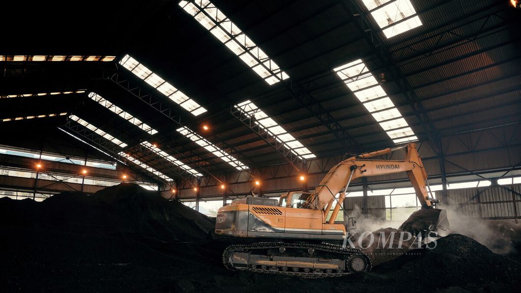 Alat berat mencampur batubara dengan cangkang sawit di Pembangkit Listrik Tenaga Uap (PLTU) Sintang, Kabupaten Sintang, Kalimantan Barat, Senin (11/10/2021). PLTU Sintang yang memiliki kapasitas terpasang sebesar 21 Megawatt (MW) menggunakan bahan bakar <i>co-firing </i>atau pencampuran biomassa dengan batubara dalam hal ini cangkang sawit. Penggunaan cangkang sawit membantu meningkatkan bauran energi terbarukan.