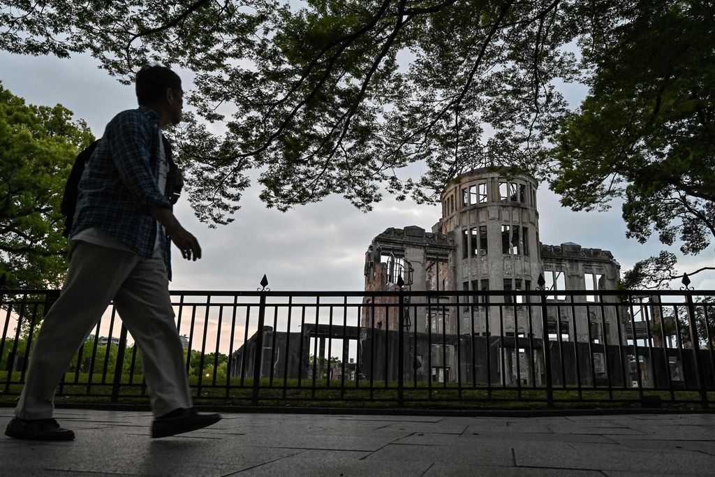 Seorang warga berjalan melintas di seberang Monumen Perdamaian Hiroshima atau dikenal pula sebagai Atomic Bomb Dome di Hiroshima pada Minggu (14/5/2023). 