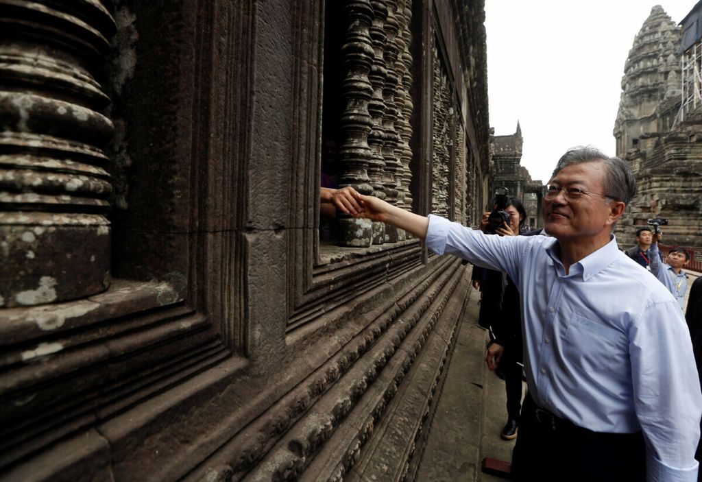 South Korean President Moon Jae-in shakes hands with his supporter during his visit to the Angkor Wat temple, in Siem Reap province, Cambodia, March 16, 2019. 