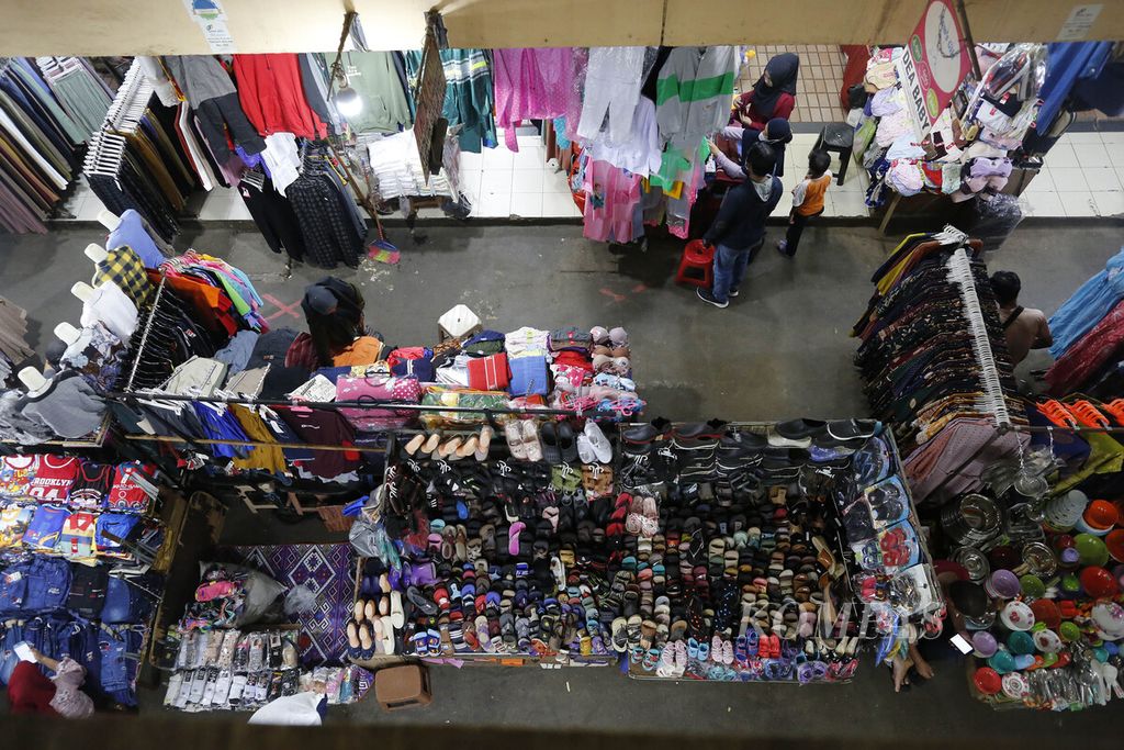 Pedagang melayani pembeli yang hendak berbelanja pakaian di Pasar Kebayoran Lama, jakarta Selatan, Kamis (13/10/2022).