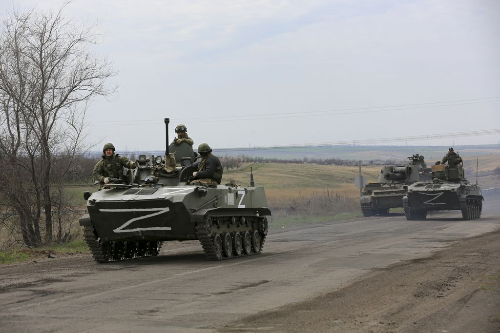 Kendaraan militer Rusia melintasi area yang dikuasai oleh kelompok separatis dukungan Kremlin di dekat kota Mariupol, Ukraina, Senin (18/4/2022). Gagal merebut Kiev, militer Rusia mengalihkan fokus untuk merebut wilayah timur dan selatan Ukraina.