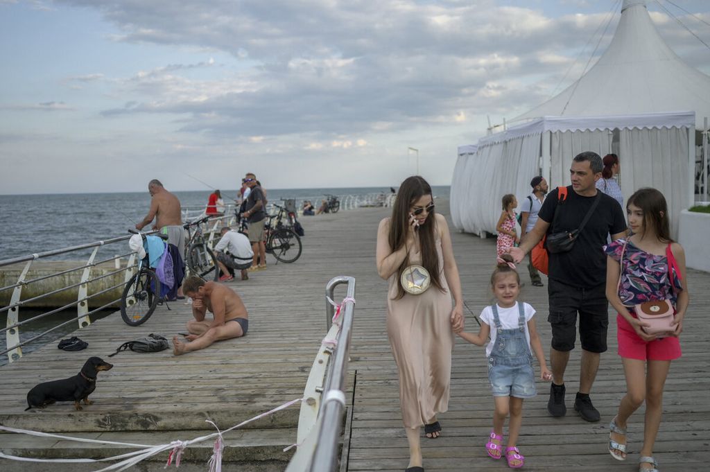 Warga menikmati sore dengan berwisata di tepi perairan pantai Odessa, di Odessa, Ukraina, Rabu (20/7/2022). 