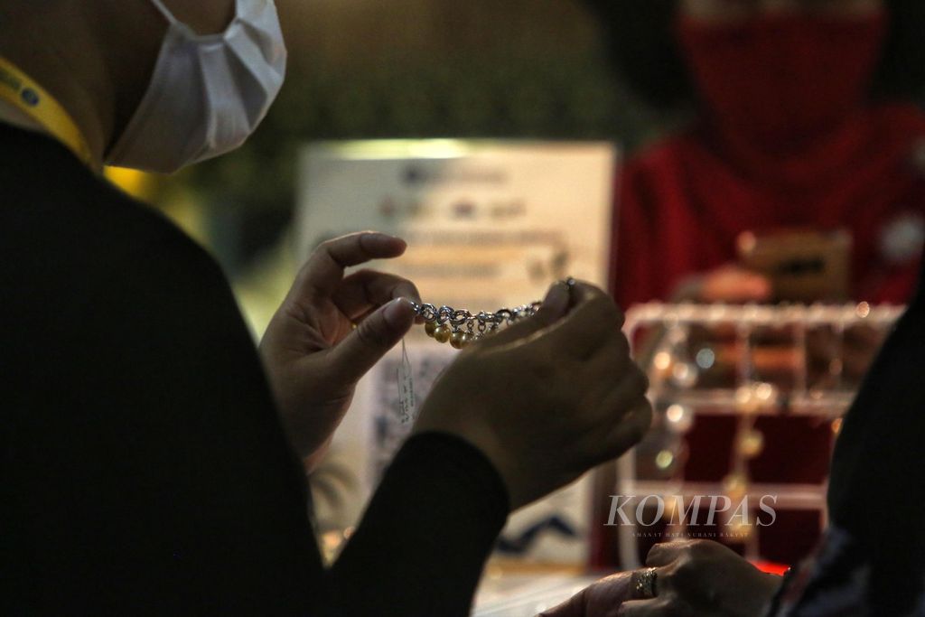 Pengunjung mencoba perhiasan mutiara saat pameran produk unggulan usaha mikro, kecil, dan menengah (UMKM) BaliNusra (Bali, Nusa Tenggara) di Mal Grand Indonesia, Jakarta, Kamis (25/3/2021). 