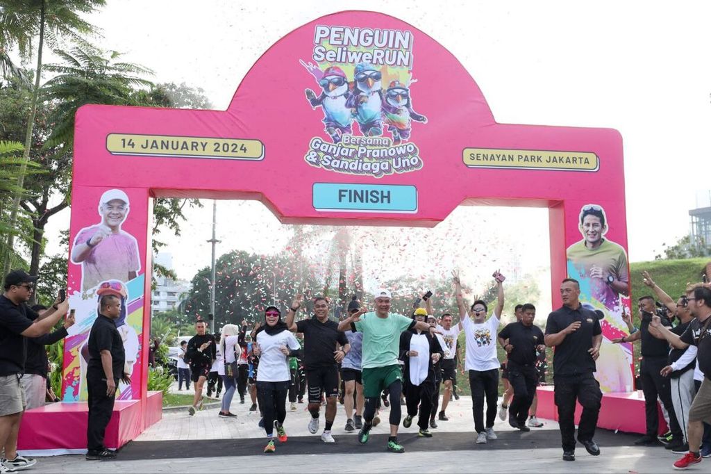 Calon presiden nomor urut 3, Ganjar Pranowo, dan istrinya, Siti Atiqoh, sampai di titik akhir (finis) seusai berlari sejauh 7 kilometer di kawasan Senayan Park, Jakarta, Minggu (14/1/2024).