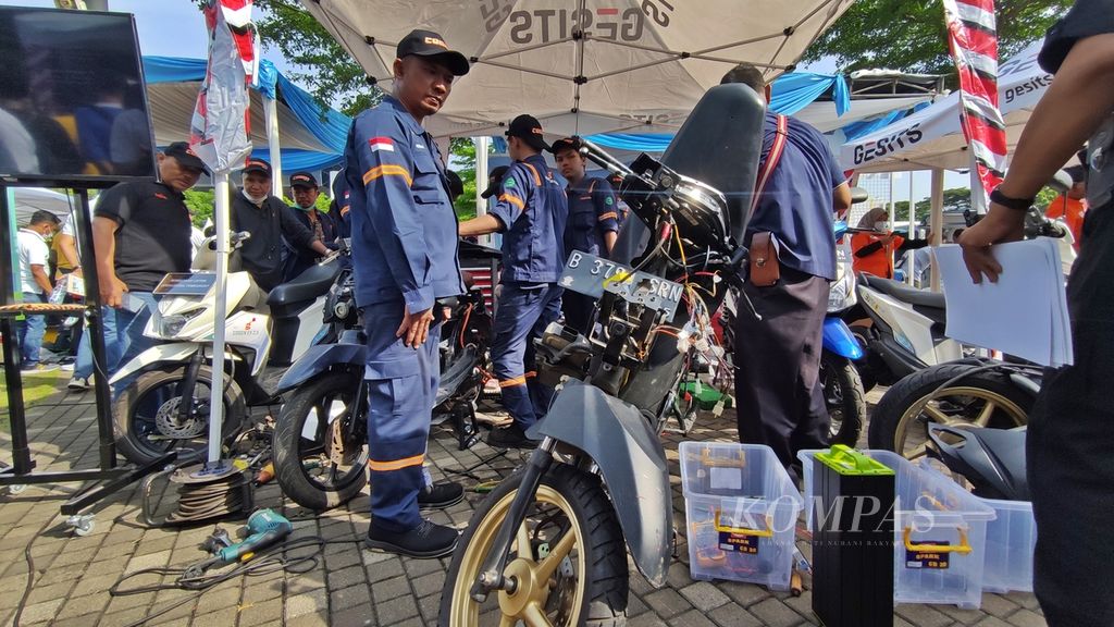 Sejumlah teknisi mengonversi sepeda motor berbahan bakar minyak menjadi sepeda motor listrik pada Electric Vehicle Funday di Plaza Timur, Gelora Bung Karno, Jakarta, Minggu (18/12/2022).
