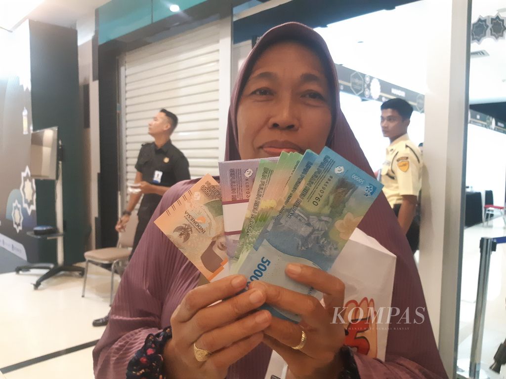 Warga menunjukkan sejumlah uang yang telah ditukarkan di Grage City Mall, Kota Cirebon, Jawa Barat, Senin (25/3/2024).