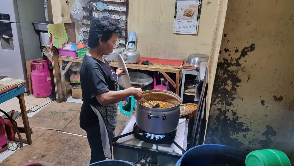 Seorang pegawai warung makan memasak bahan makanan di salah satu sudut Pasar Kosambi, Kota Bandung, Jawa Barat, Rabu (13/7/2022). Warung makan ini menggunakan tabung gas 12 kilogram untuk memasak dan bisa menghabiskan satu tabung untuk tiga hari.