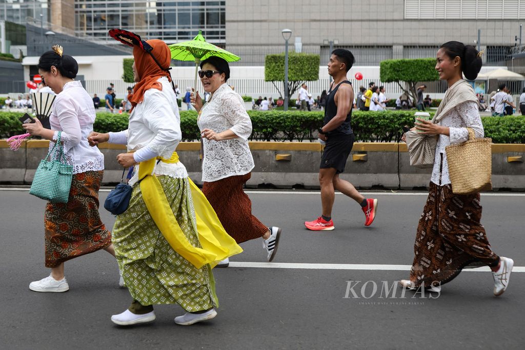 Peserta pawai CFD Kartinian berlari di Jalan MH Thamrin, Jakarta, Minggu (21/4/2024). Perempuan Berkebaya Indonesia dan Kebaya Menari menyelenggarakan pawai CFD Kartinian.
