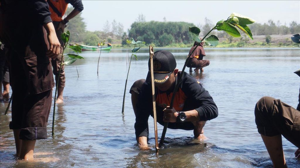 Para pelajar dan sukarelawan dari sejumlah komunitas menanam mangrove di Pantai Laguna, Lembupurwo, Kecamatan Mirit, Kebumen, Jawa Tengah, Selasa (30/7/2019). Mangrove dinilai efektif mengurangi terjangan tsunami hingga 50 persen.