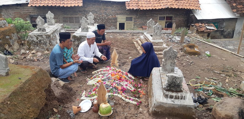Keluarga berdoa di makam Rasni di Desa Cangkoak, Kecamatan Dukupuntang, Kabupaten Cirebon, Jawa Barat, Senin (27/11/2023). Rasni merupakan korban pembunuhan yang diduga dilakukan oleh mantan suami sirinya.